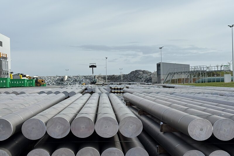 Coralium résumé en une photo : au fond, les déchets d'aluminium - issus de chute de production et du démantelement de produits du bâtiment - et au premier plan, les billettes d'aluminium R80 recyclé dans la fonderie.